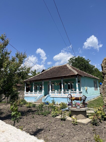 A house with a tiled roof, surrounded by greenery and a clear sky. 3