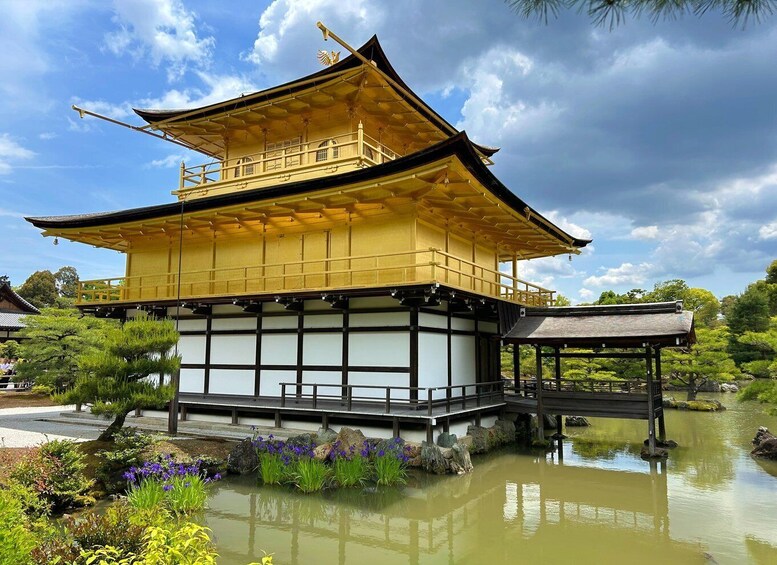 A traditional Japanese building with a golden roof, surrounded by a pond and greenery. 2