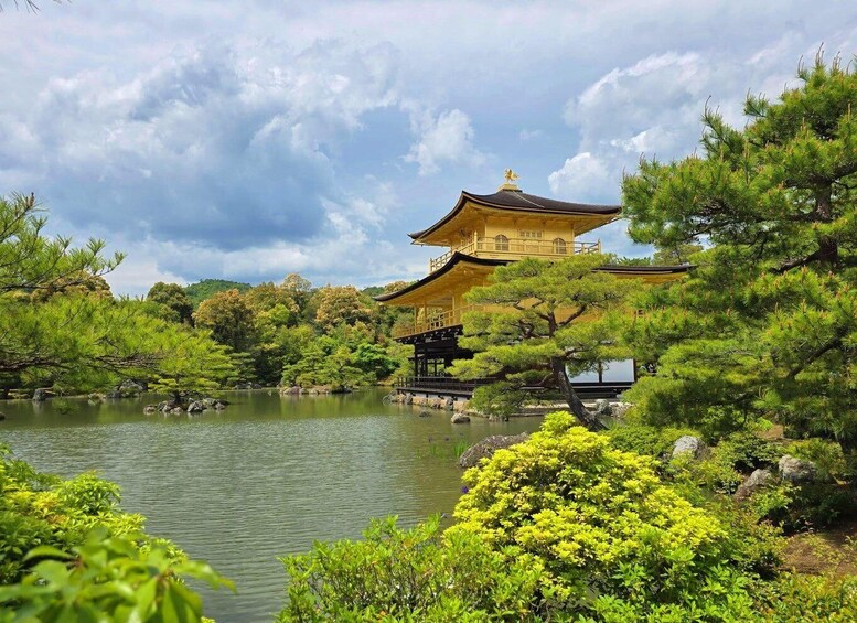 A traditional Japanese building with a golden roof, surrounded by lush greenery and a calm pond. 3