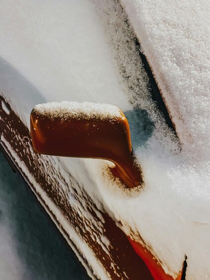 A close-up of a car handle covered in snow. 2