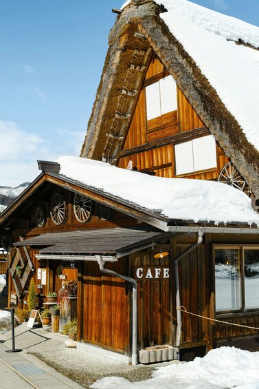 A wooden building with a snow-covered roof and a sign that reads 'CAFE.' 5