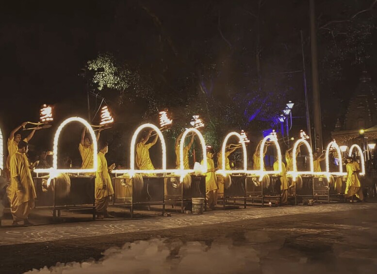 A nighttime outdoor event with people performing a ritual with illuminated arches. 4