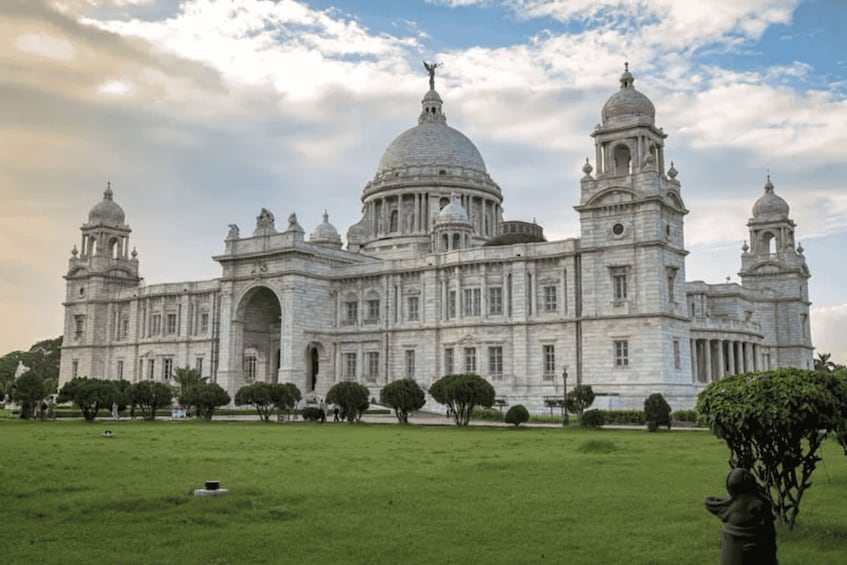 A large, historic building with multiple domes and towers, surrounded by a well-maintained lawn and trees. 1
