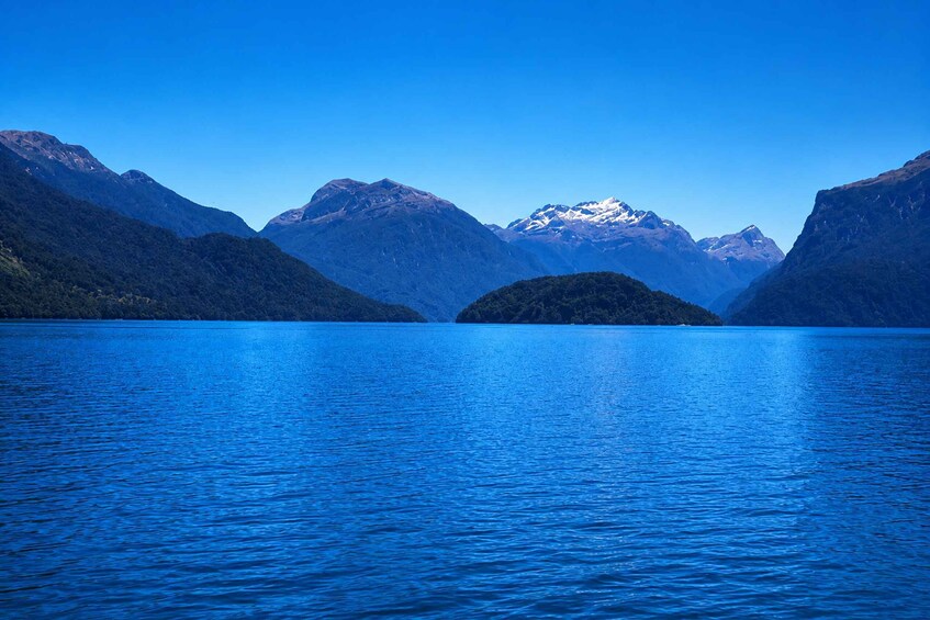 A calm lake surrounded by mountains with snow-capped peaks. 2