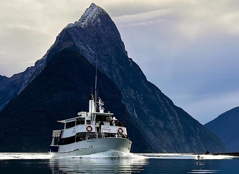 A boat on calm water with a large mountain in the background. 3