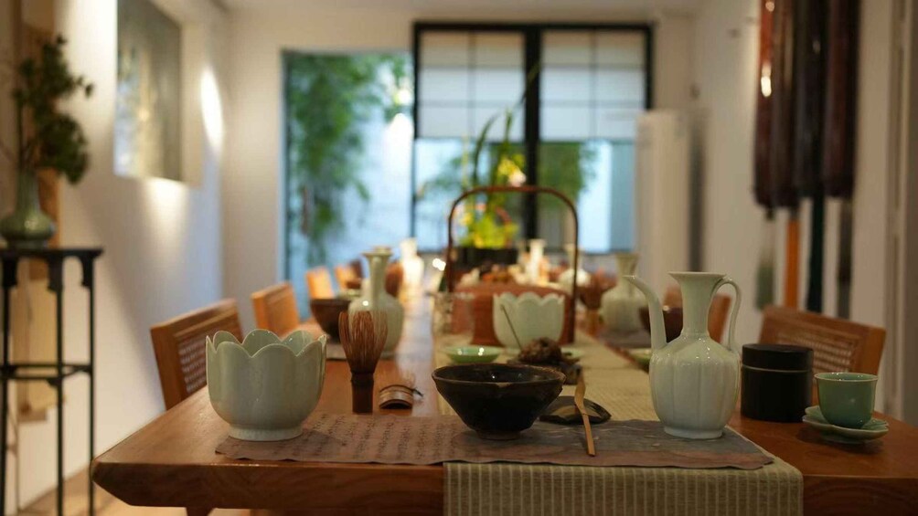 A dining table with various ceramic dishes and a tea set. 2