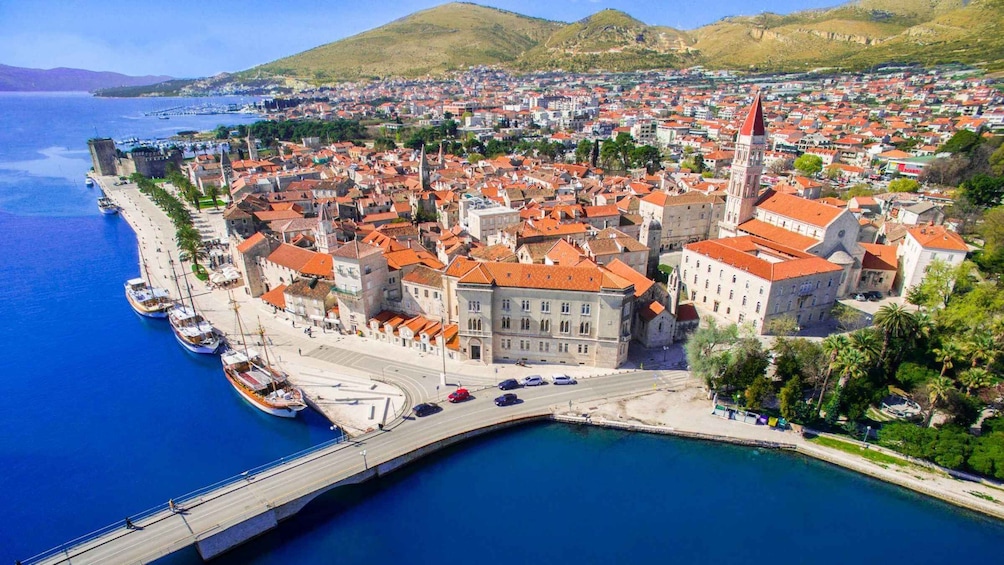 A coastal city with a prominent historic building, a bridge, and a marina. 1