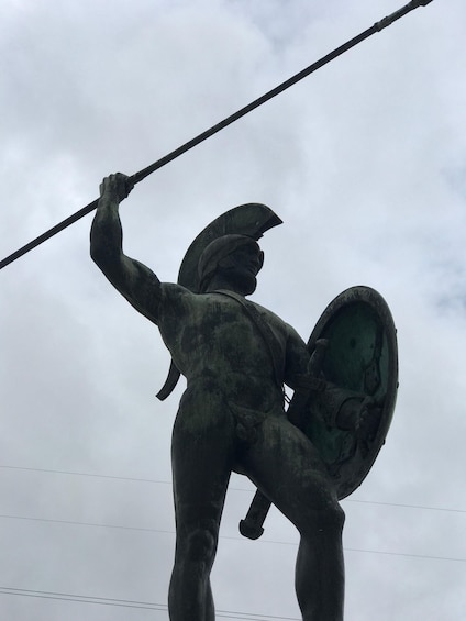 A bronze statue of a warrior holding a spear and shield. 1