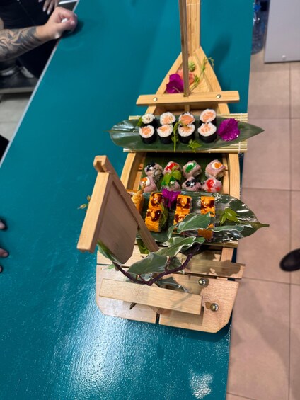A sushi display with various types of sushi on wooden stands. 1