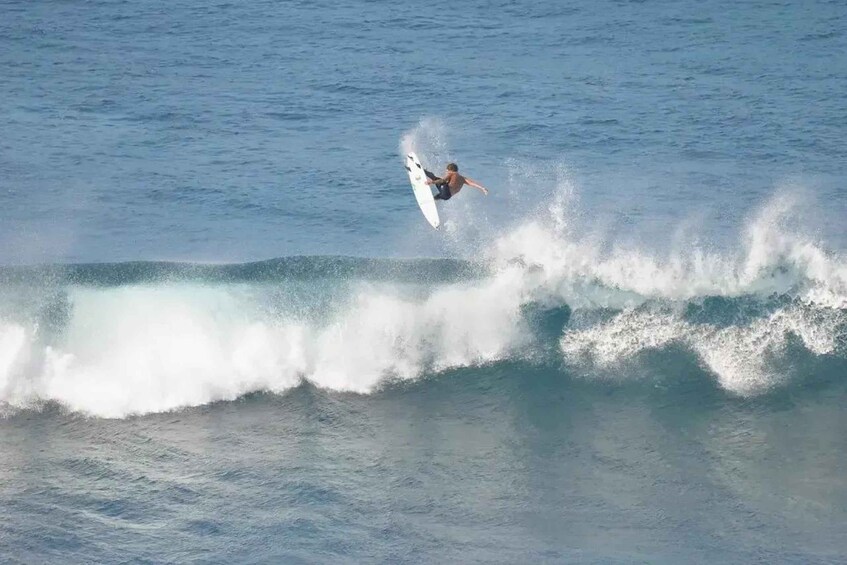 A surfer riding a wave in the ocean. 5