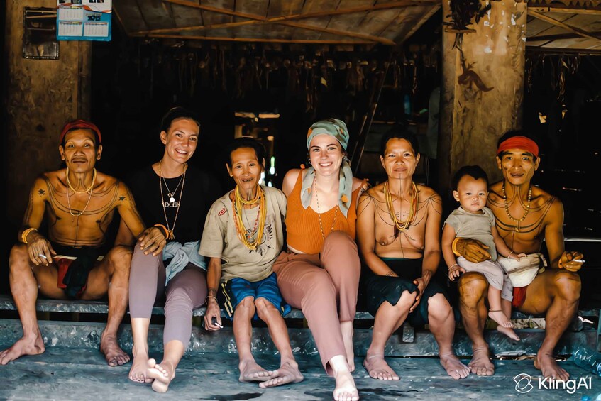 A group of people sitting on steps in a rustic setting with wooden beams and a hanging artifact. 4