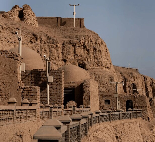 Ancient ruins with arched doorways and a watchtower. 1