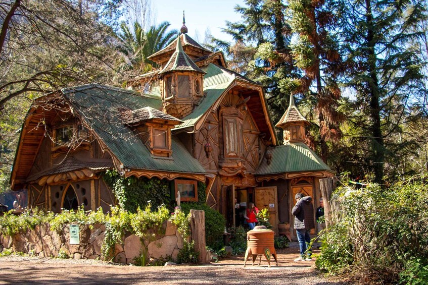 A wooden house with a green roof surrounded by trees and greenery. 5