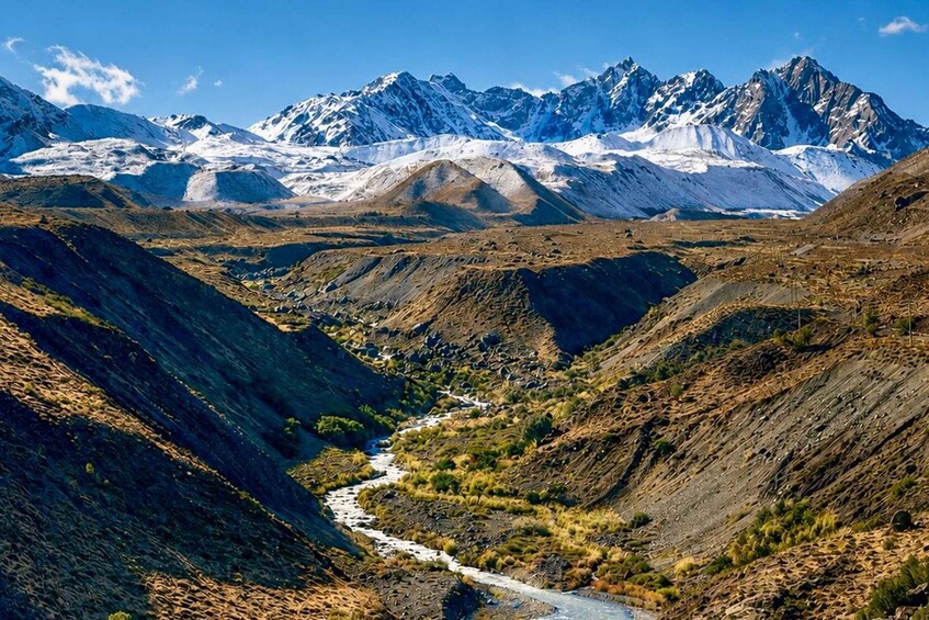 A river winding through a mountainous valley with snow-capped peaks in the background. 3