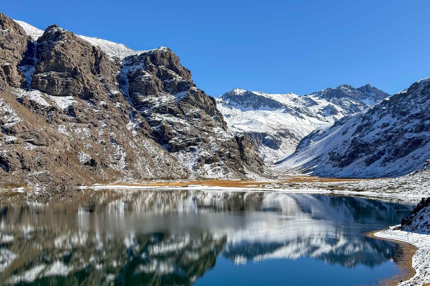 A mountain lake with snow-covered peaks and a clear reflection. 1