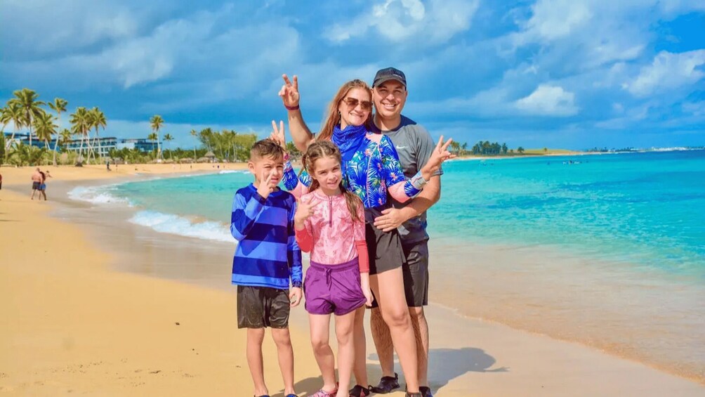 A family on a beach with palm trees and clear blue water. 4