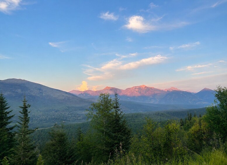 A mountain range with a clear sky and a forested valley. 2