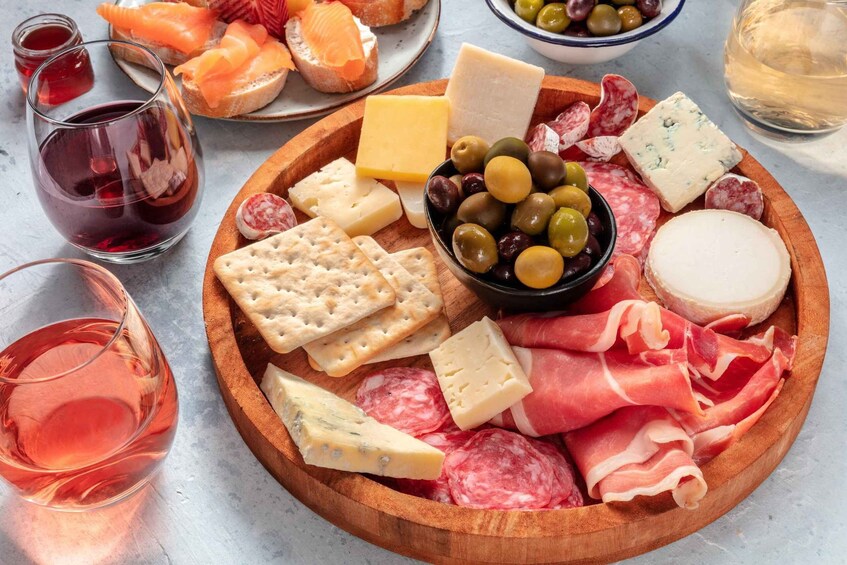 A charcuterie board with various cheeses, meats, olives, and crackers. 2