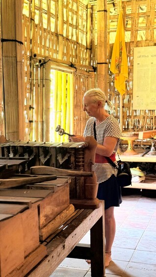 A person working with wooden tools in a workshop with bamboo walls. 2