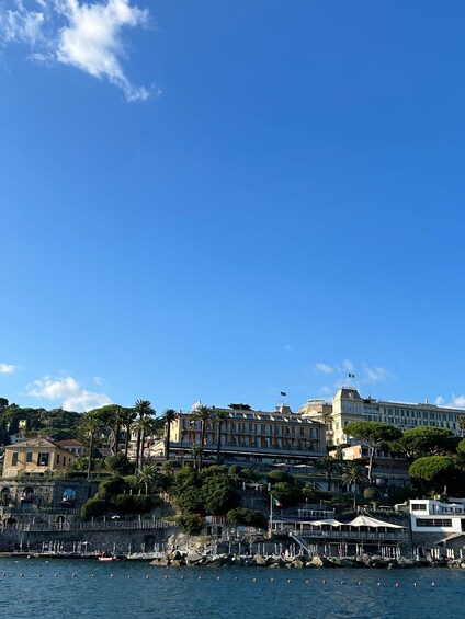 A coastal cityscape with historic buildings, a marina, and clear blue skies. 5
