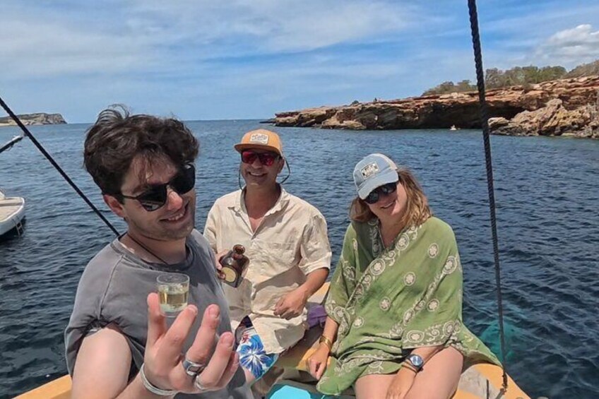 Three people on a boat with rocky coastline in the background. 5
