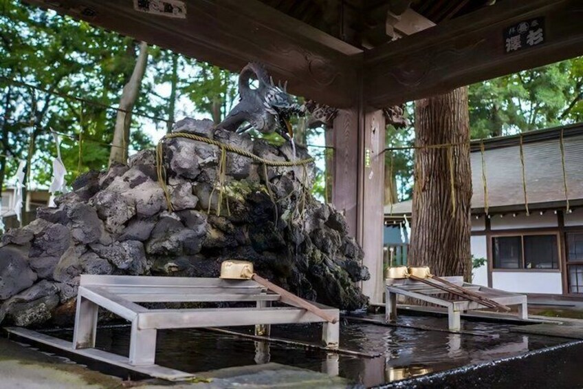 A traditional Japanese rock garden with a wooden bench and a small pond. 3