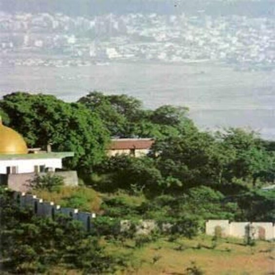 A building with a golden dome, surrounded by greenery and a body of water in the background. 4