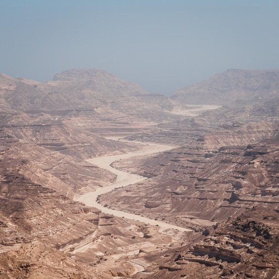 A rugged canyon landscape with a winding river. 1