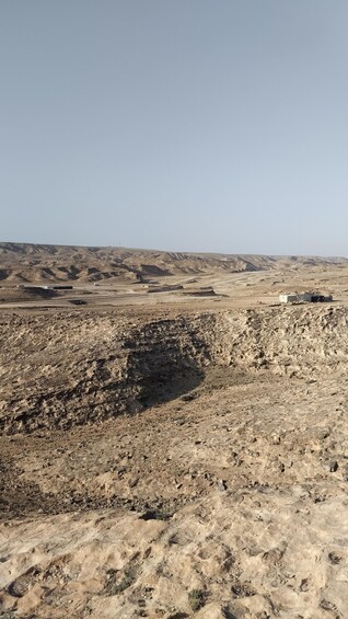 A barren landscape with rocky terrain and sparse vegetation. 1