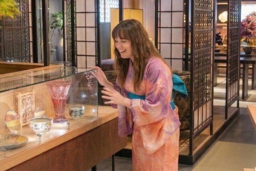 A person in a tie-dye robe at a counter with decorative glassware. 5
