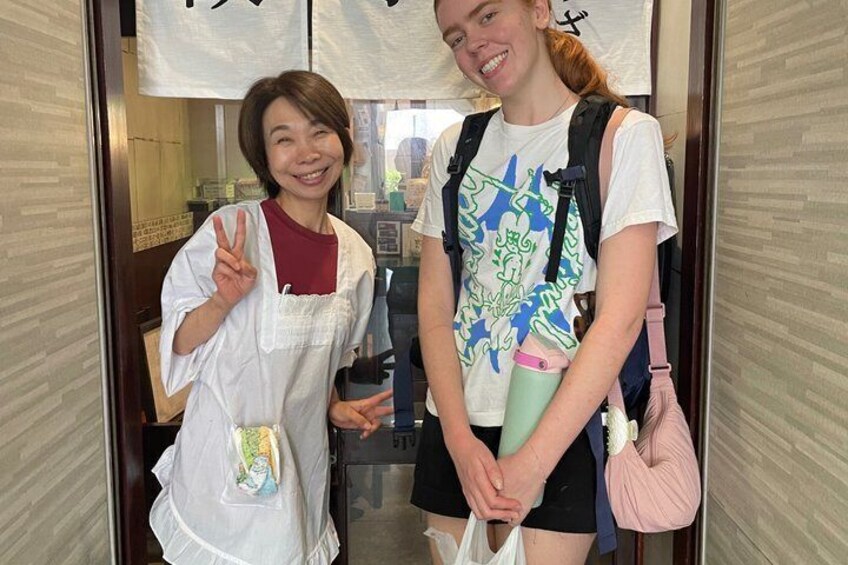 Two people standing in a doorway with a sign above them. 3