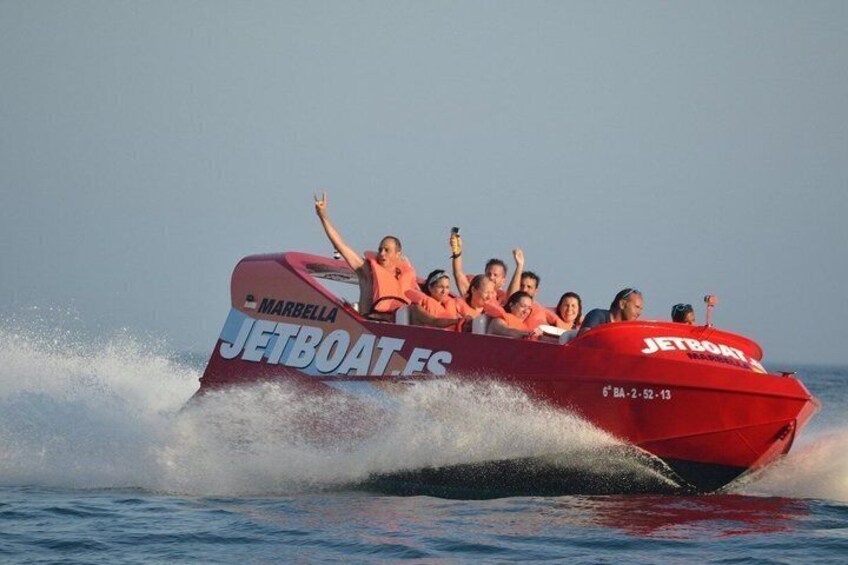 A red jetboat with 'JETBOAT FC' and 'MARBELLA' on the side, moving through water. 4