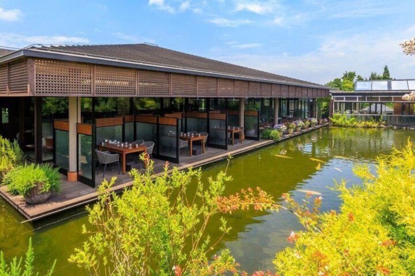 A riverside restaurant with outdoor seating and a koi pond. 5