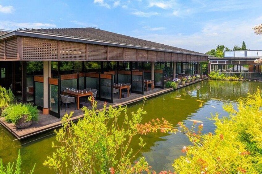 En restaurang vid floden med uteservering och en damm med koi-karpar. 4