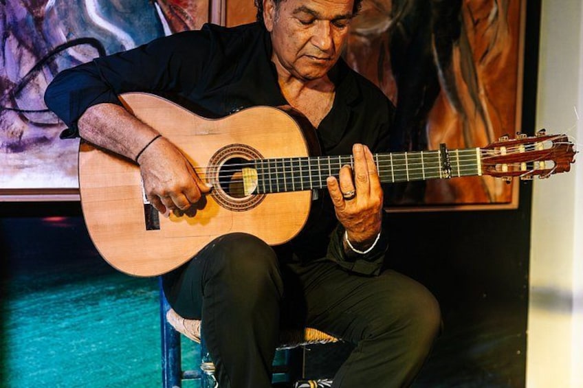 A person playing an acoustic guitar. 5