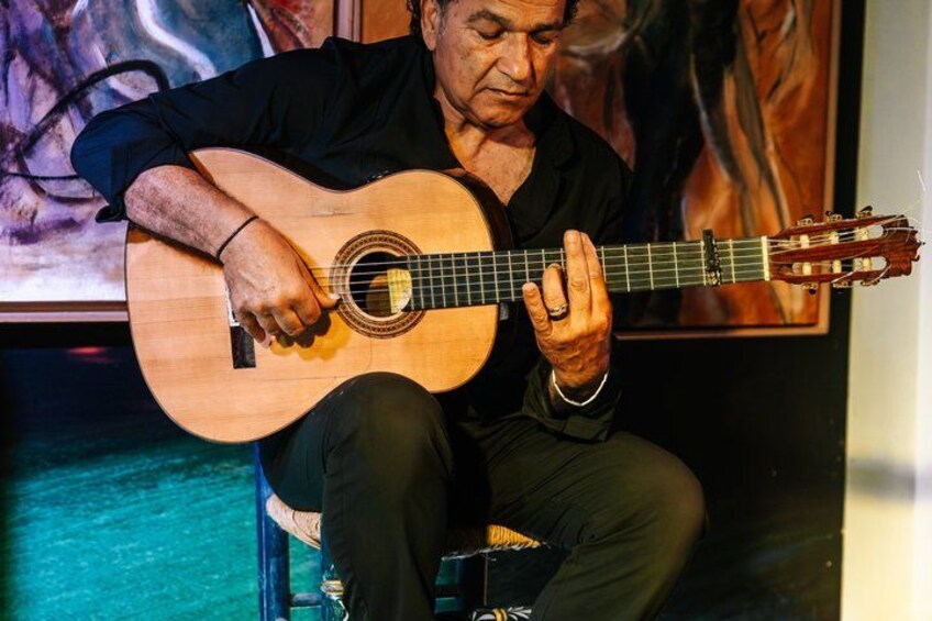 Una persona tocando una guitarra acústica. 4