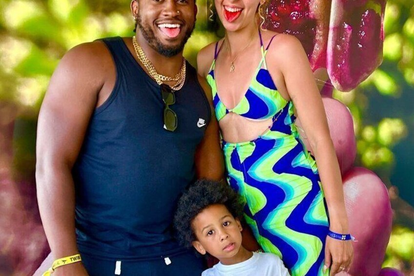 A person in a blue and green patterned dress, a child in a white shirt, and another person in a dark tank top. 3