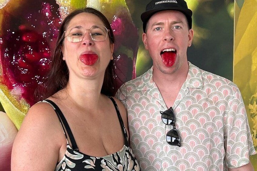 Two people in patterned clothing with a colorful background. 2