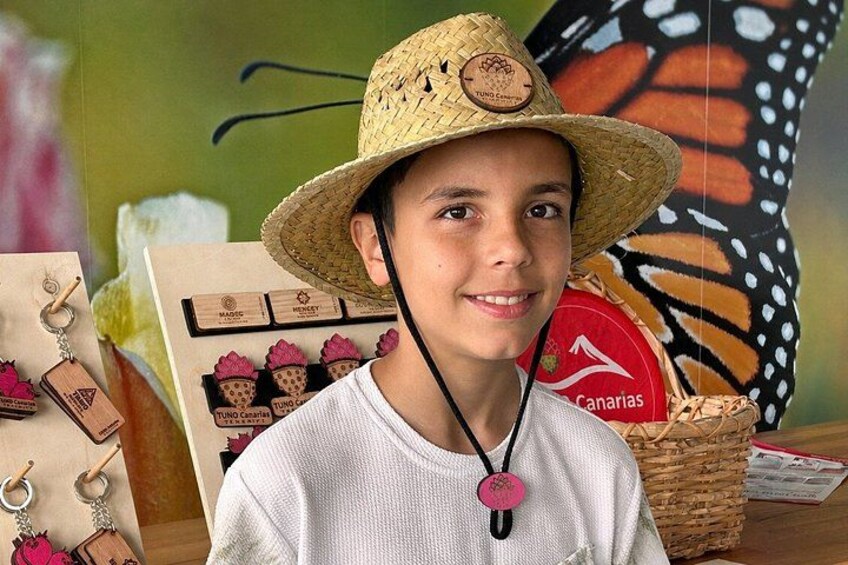 A person wearing a straw hat and a white shirt, with a butterfly wing pattern in the background. 4