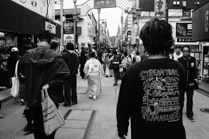 A crowded urban street with people walking, shops, and signs in a foreign language. 2