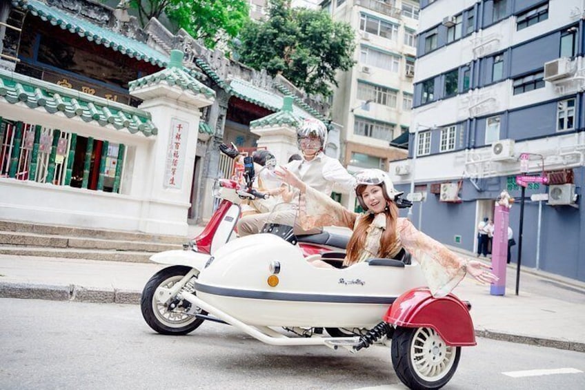 A person in a white costume riding a motorcycle with a sidecar. 1