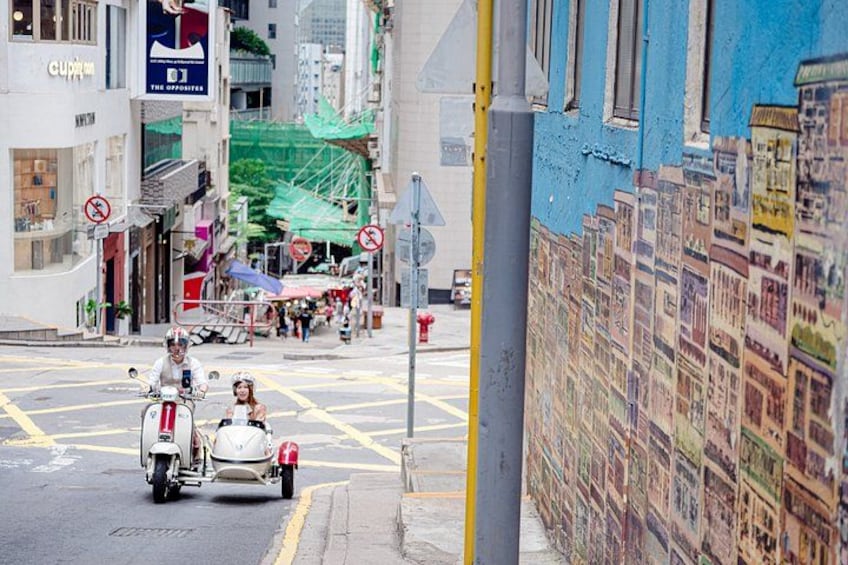 A street with a mural, a scooter, and a pedestrian crossing. 2