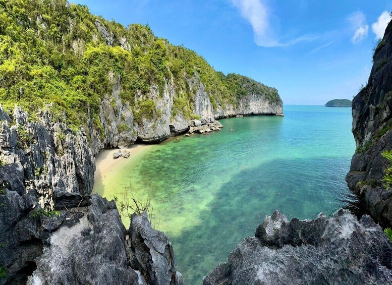 A coastal landscape with clear turquoise waters, rocky cliffs, and lush greenery. 1
