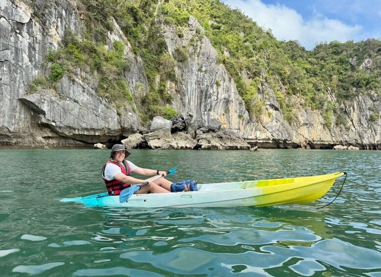 A person kayaking on a calm river with rocky cliffs in the background. 5