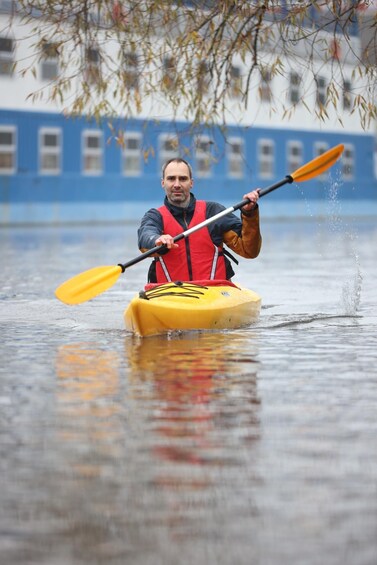 A person kayaking in a flooded urban area. 2