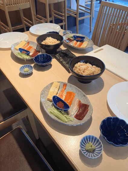 A table with various dishes including sashimi, rice, and pickled vegetables. 3