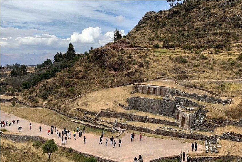 Un sitio arqueológico con ruinas y una multitud de visitantes. 2