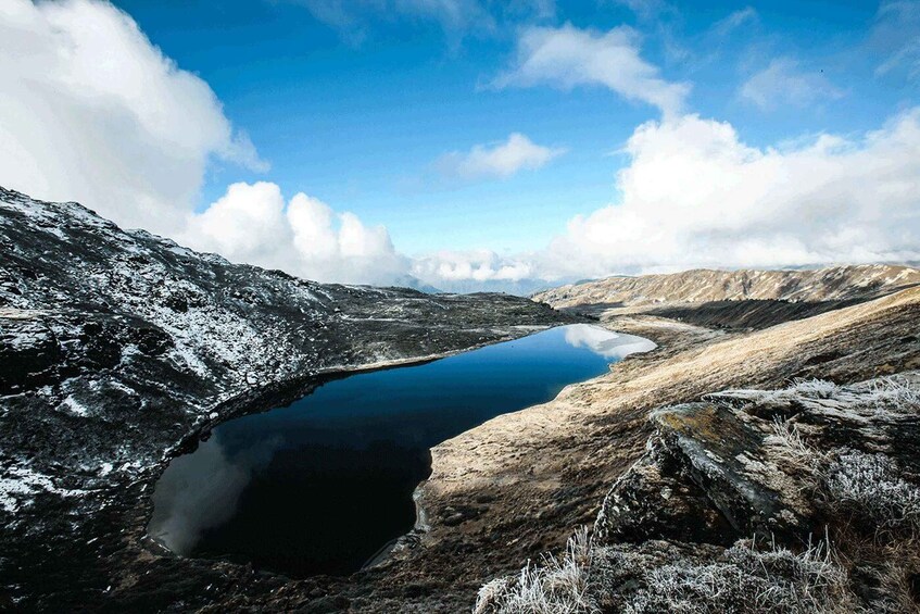 A snow-covered landscape with a lake and mountains in the background. 1