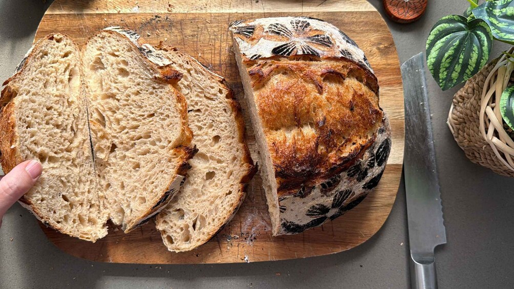 A loaf of artisan bread on a wooden cutting board, sliced and ready to serve. 3