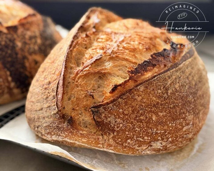 A loaf of artisan sourdough bread with a crusty exterior and a visible air pocket. 2